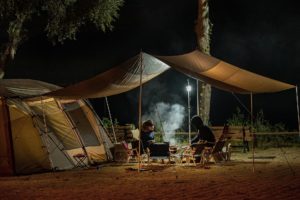 Tent in het donker met kampvuur